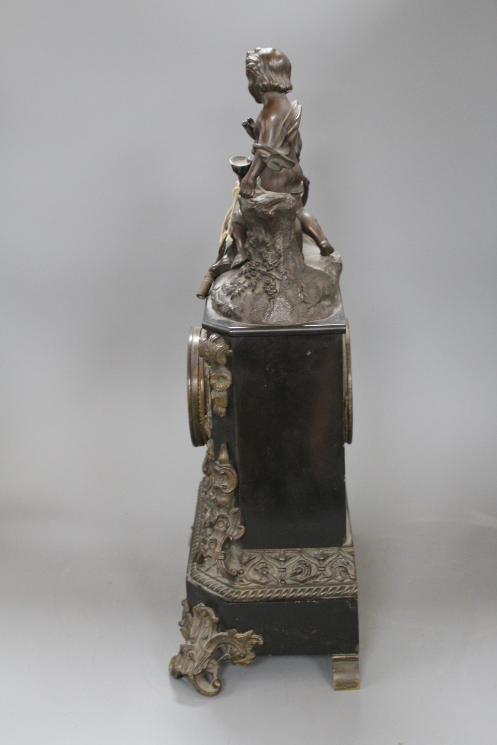 A Victorian bronze mounted black slate mantel clock, with enamelled dial, surmounted with figures of putti, height 48cm